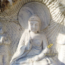 Marble relief of Shakyamuni Buddha with two attendants, carved in raw stone